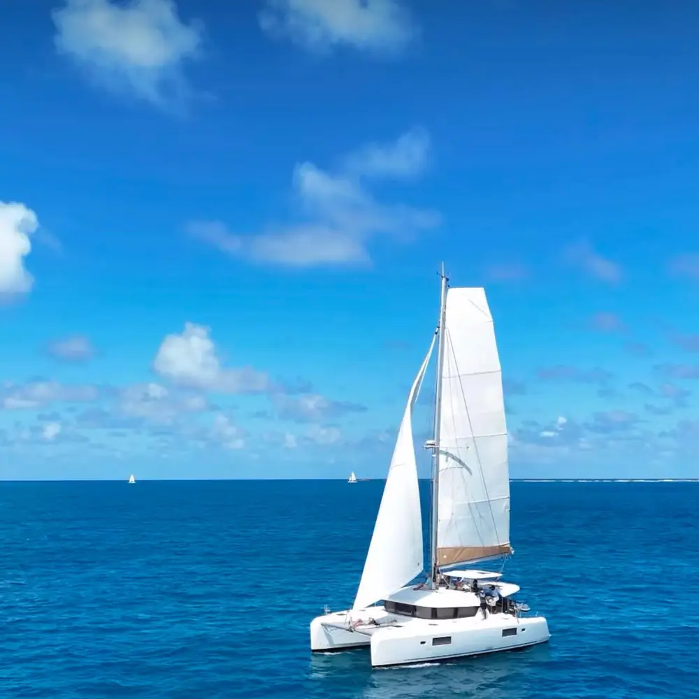 Sail catamaran with white sails on clear blue Caribbean water - flagship private catamaran charter in Puerto Rico